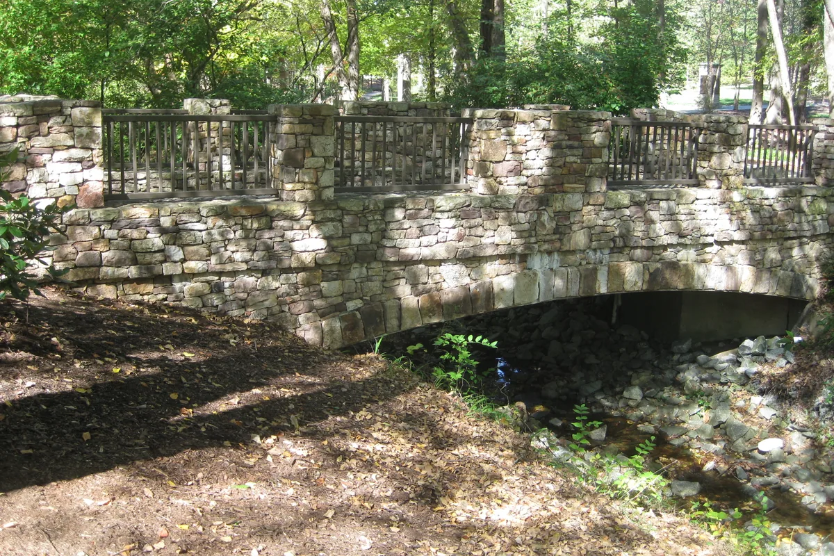 Stone bridge over the creek at Tanger Family Bicentennial Garden